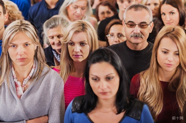 Crowd of serious people standing together.